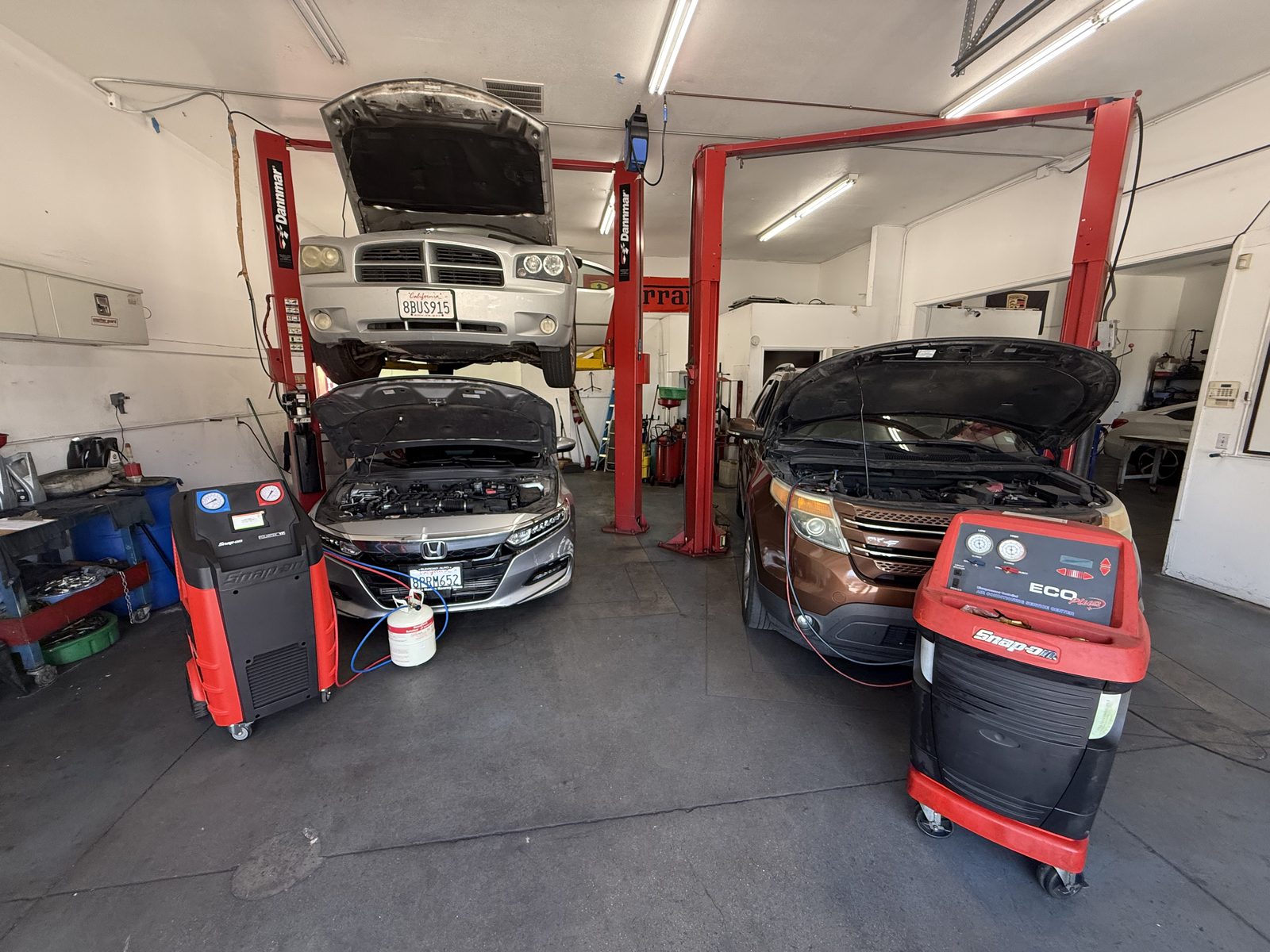 Inside the shop, with cars on both lifts and A/C machines ready